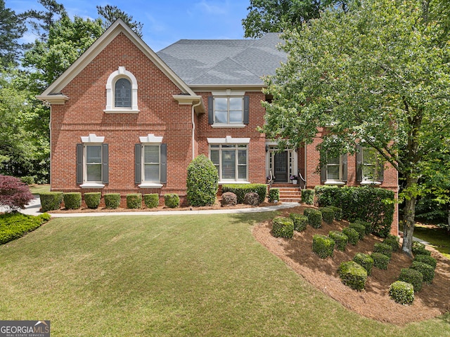 view of front of home with brick siding and a front yard