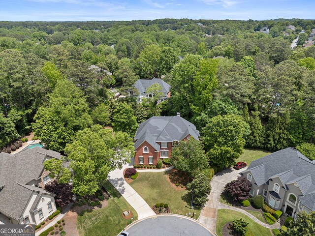 aerial view of residential area featuring a forest
