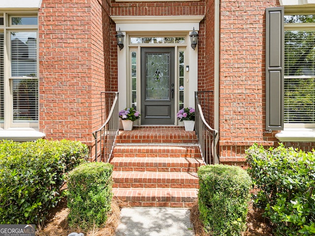view of exterior entry with brick siding