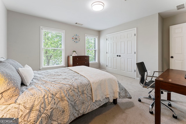 carpeted bedroom with a closet and an office area