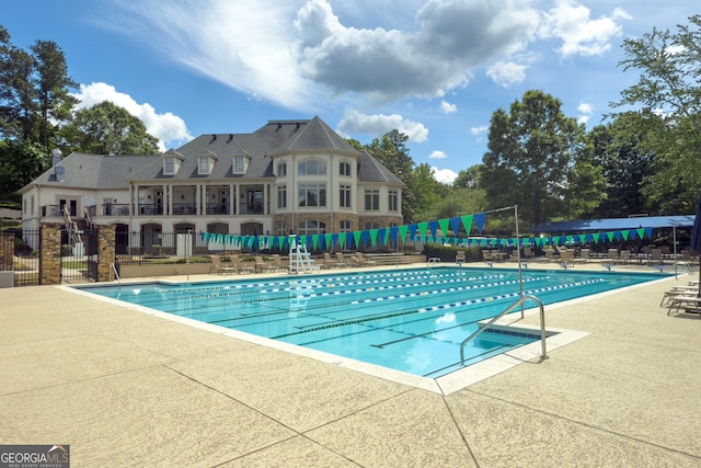community pool featuring fence and a patio