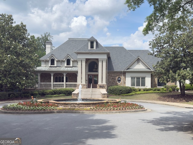 view of front of home with a chimney and roof with shingles