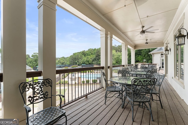 wooden terrace featuring a ceiling fan and outdoor dining area