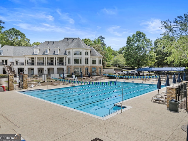 community pool featuring fence and a patio area