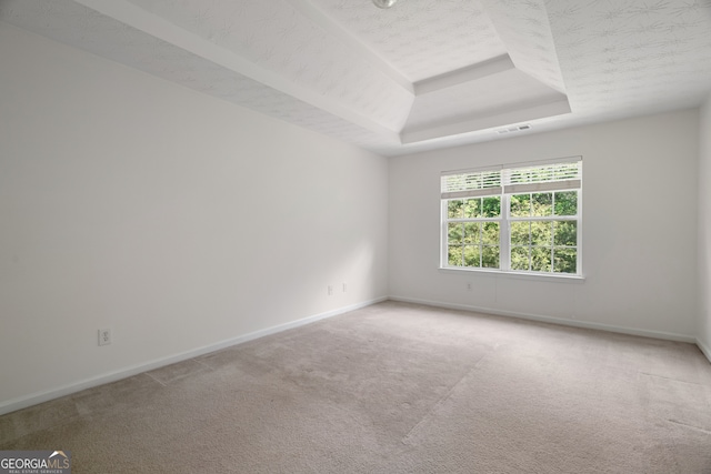 unfurnished room with a tray ceiling, baseboards, and carpet flooring