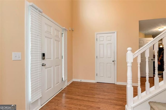 3265 Watson Gate Rd, Loganville, GA 30052 - foyer featuring stairway, wood finished floors, baseboards, and a high ceiling