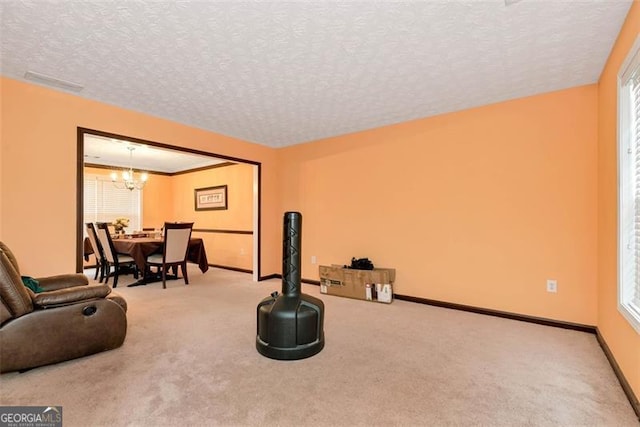 3265 Watson Gate Rd, Loganville, GA 30052 - living area with a chandelier, a textured ceiling, carpet, and baseboards