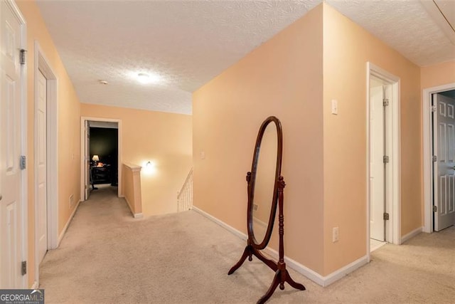 3265 Watson Gate Rd, Loganville, GA 30052 - hallway with light carpet, a textured ceiling, and an upstairs landing