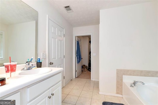 3265 Watson Gate Rd, Loganville, GA 30052 - bathroom featuring tile patterned floors, a bath, vanity, a textured ceiling, and baseboards
