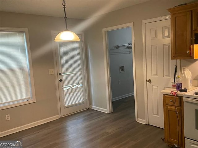 248 Dreamland Cir, Winder, GA 30680 - kitchen with electric range, brown cabinetry, dark wood finished floors, baseboards, and hanging light fixtures
