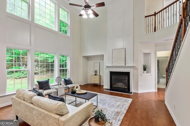 3153 Daleview Way SW, Atlanta, GA 30331 - living room featuring a high ceiling, healthy amount of natural light, a ceiling fan, stairs, and wood finished floors
