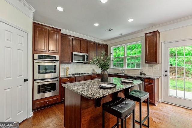 3153 Daleview Way SW, Atlanta, GA 30331 - kitchen with appliances with stainless steel finishes, a kitchen bar, dark stone countertops, ornamental molding, and decorative backsplash