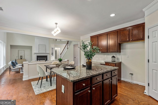 3153 Daleview Way SW, Atlanta, GA 30331 - kitchen with dark stone counters, backsplash, dark wood-style floors, ornamental molding, and a fireplace