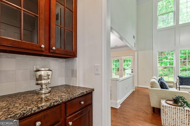 3153 Daleview Way SW, Atlanta, GA 30331 - kitchen with tasteful backsplash, crown molding, dark stone countertops, glass insert cabinets, and wood finished floors