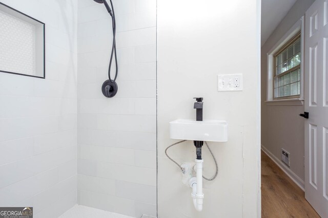 3193 Trasher Cir, Decatur, GA 30032 - bathroom featuring a tile shower, wood finished floors, a sink, and baseboards