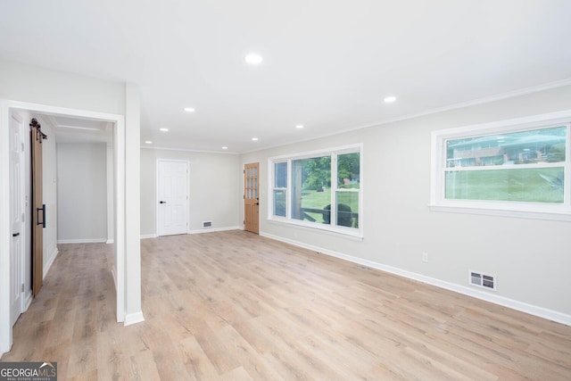 3193 Trasher Cir, Decatur, GA 30032 - unfurnished living room featuring crown molding, baseboards, recessed lighting, light wood-type flooring, and a barn door