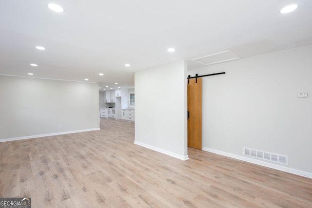 3193 Trasher Cir, Decatur, GA 30032 - unfurnished living room featuring recessed lighting, a barn door, light wood-style flooring, and baseboards