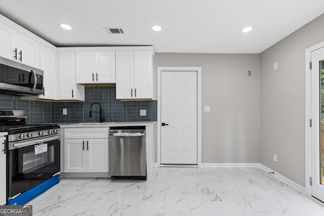 4657 Lou Ivy Rd, Peachtree Corners, GA 30096 - kitchen featuring appliances with stainless steel finishes, a sink, baseboards, tasteful backsplash, and white cabinets