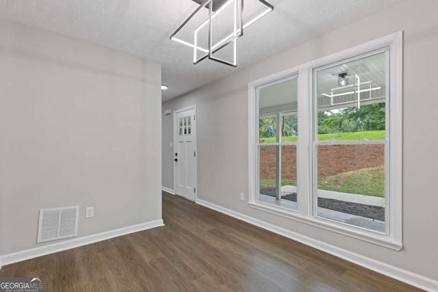 4657 Lou Ivy Rd, Peachtree Corners, GA 30096 - unfurnished dining area with a chandelier, dark wood-type flooring, baseboards, and a textured ceiling