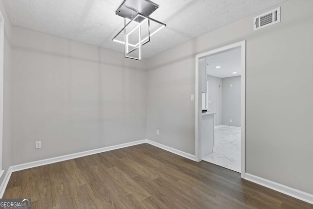 4657 Lou Ivy Rd, Peachtree Corners, GA 30096 - spare room featuring wood finished floors, baseboards, and a textured ceiling