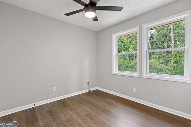 4657 Lou Ivy Rd, Peachtree Corners, GA 30096 - spare room featuring baseboards, dark wood-style flooring, and ceiling fan