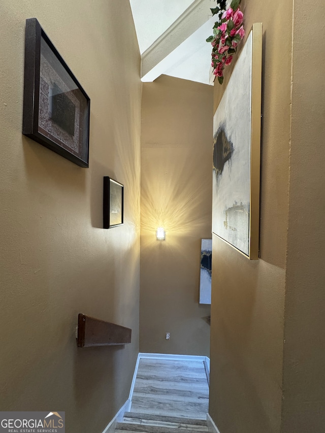 staircase with wood finished floors and baseboards