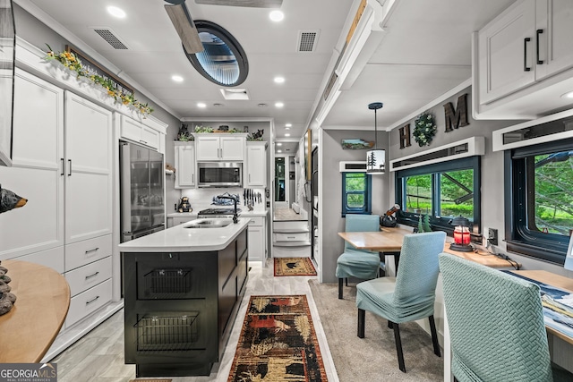 344 Choestoe Falls Cir, Blairsville, GA 30512 - kitchen with appliances with stainless steel finishes, light countertops, white cabinets, tasteful backsplash, and a kitchen island with sink