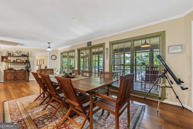dining area featuring wood finished floors, crown molding, baseboards, and french doors
