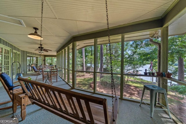 sunroom / solarium featuring carpet floors, ceiling fan, and outdoor dining space
