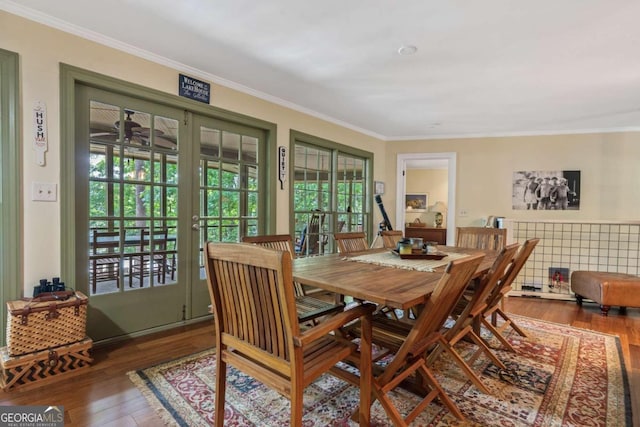 dining area with wood finished floors, healthy amount of natural light, and ornamental molding