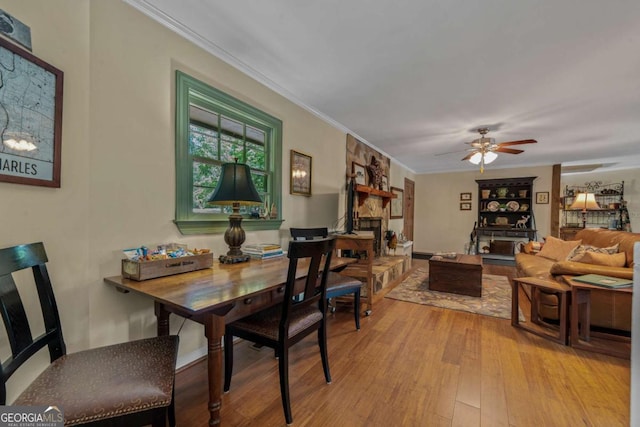 dining room featuring wood finished floors, ornamental molding, and ceiling fan