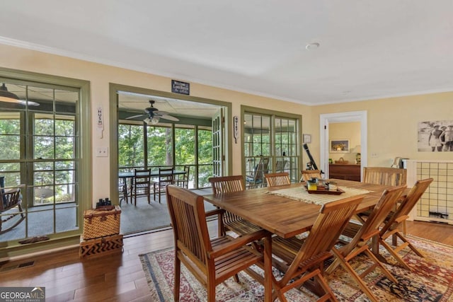 dining room featuring wood finished floors, ornamental molding, healthy amount of natural light, and a ceiling fan