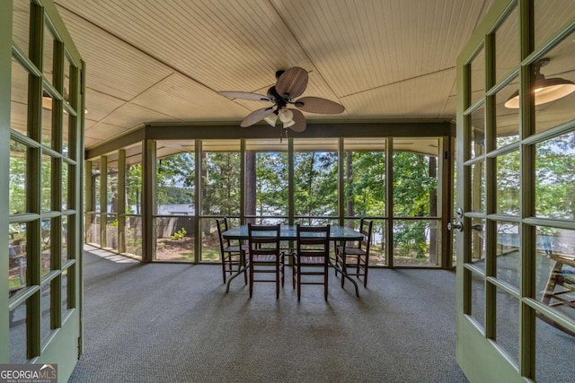 sunroom / solarium featuring expansive windows, a ceiling fan, carpet flooring, plenty of natural light, and wood ceiling