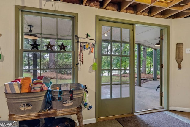 doorway to outside with healthy amount of natural light, baseboards, and carpet