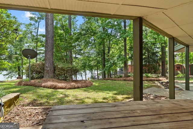 wooden deck featuring a storage unit, an outbuilding, and a lawn
