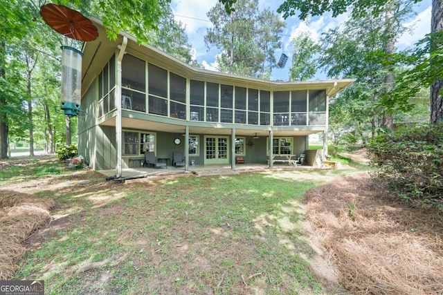 rear view of house with a sunroom, french doors, and a patio
