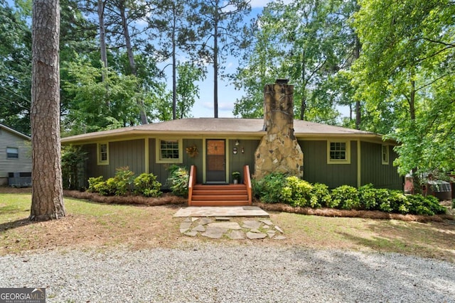 ranch-style house with a chimney and central AC
