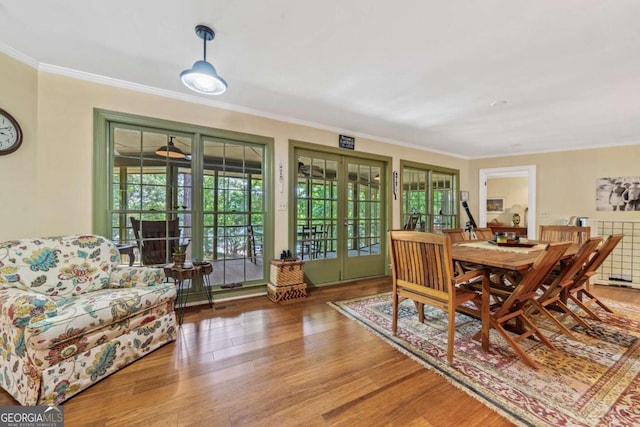 dining space with french doors, wood finished floors, and ornamental molding