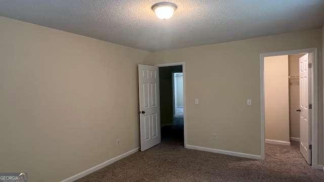 7055 Blairs View Dr Unit 1, Austell, GA 30168 - unfurnished bedroom featuring carpet flooring, baseboards, a spacious closet, and a textured ceiling