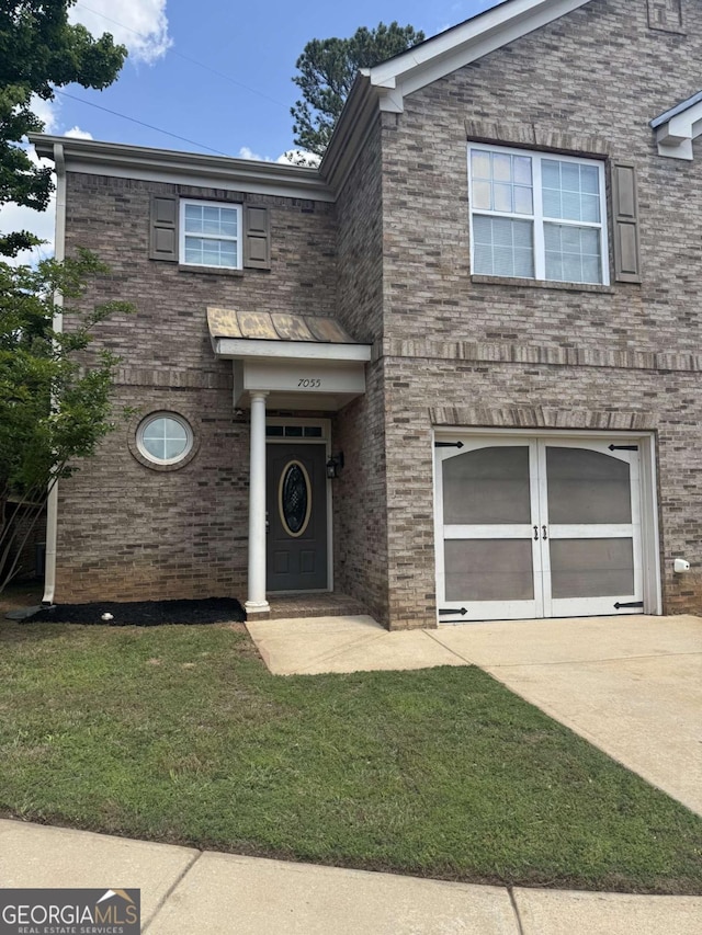 7055 Blairs View Dr Unit 1, Austell, GA 30168 - view of front of house featuring concrete driveway, a front yard, a garage, and brick siding