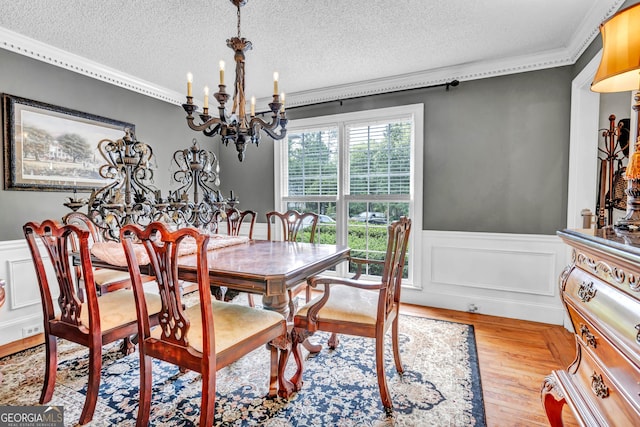 4250 Edgewater Ct NW, Kennesaw, GA 30144 - dining room featuring crown molding, a textured ceiling, a chandelier, wainscoting, and wood finished floors