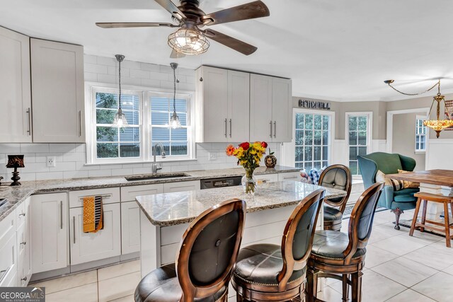 4250 Edgewater Ct NW, Kennesaw, GA 30144 - kitchen with a sink, a ceiling fan, light tile patterned floors, backsplash, and a wainscoted wall