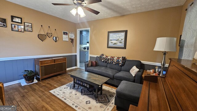 112 Hilltop Dr, Newborn, GA 30056 - living room featuring wood finished floors, a ceiling fan, a wainscoted wall, and a textured ceiling