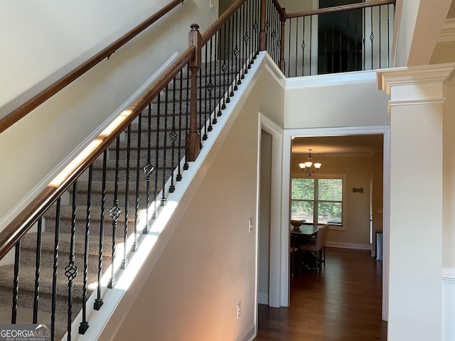 101 Elkins Blvd, Locust Grove, GA 30248 - staircase featuring a chandelier, wood finished floors, and a towering ceiling