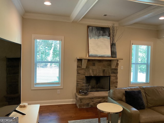 living area with beam ceiling, dark wood finished floors, ornamental molding, a stone fireplace, and recessed lighting