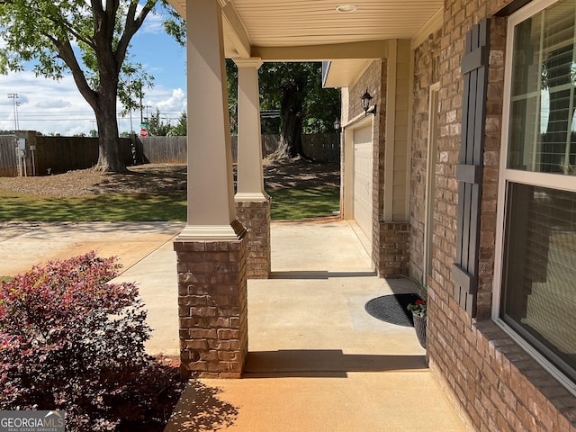 view of patio / terrace with fence and a porch