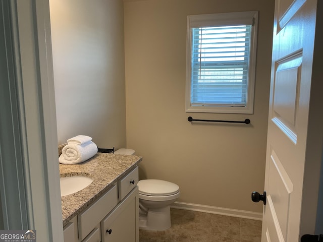 bathroom featuring vanity, baseboards, toilet, and tile patterned flooring