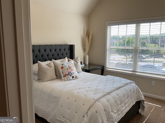 bedroom with carpet flooring, vaulted ceiling, and baseboards