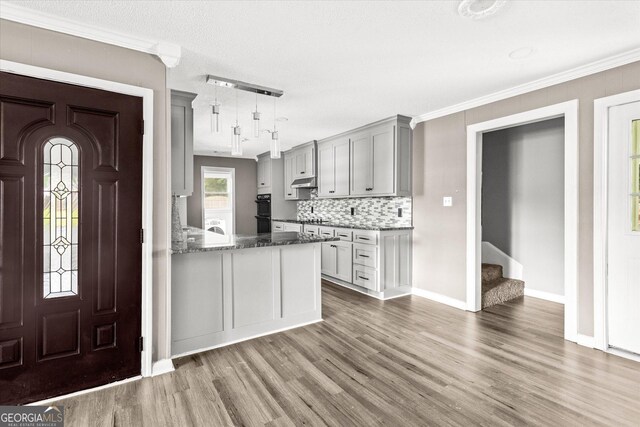 125 Sycamore Dr, Athens, GA 30606 - kitchen with wood finished floors, gray cabinets, decorative backsplash, stone countertops, and pendant lighting