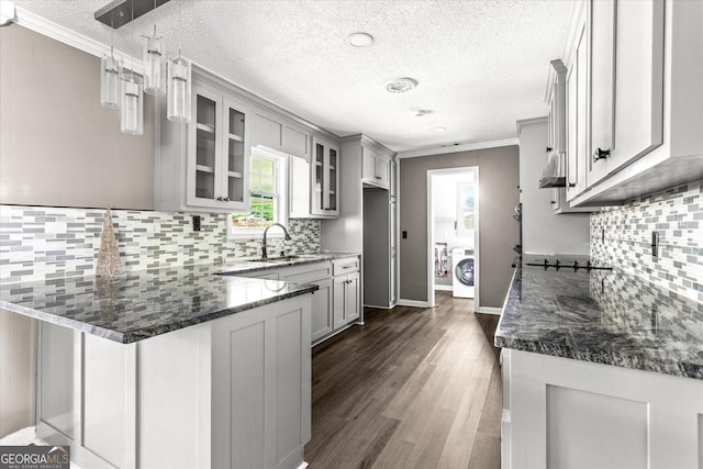 125 Sycamore Dr, Athens, GA 30606 - kitchen with a peninsula, glass insert cabinets, a textured ceiling, dark wood-type flooring, and dark stone counters